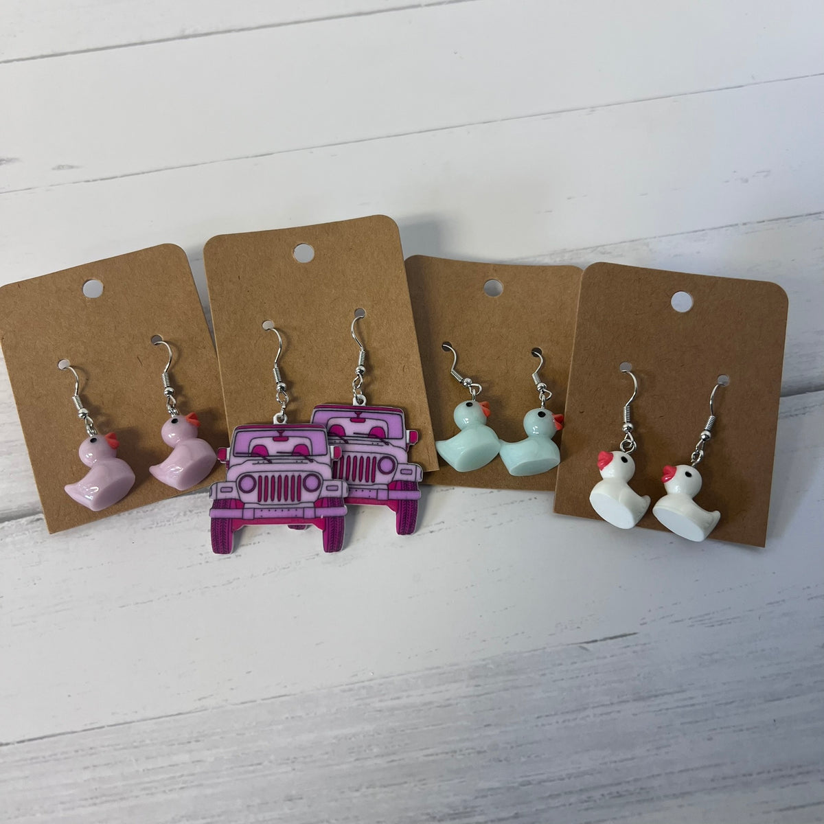Set of earrings on brown card backing with a white wooden background