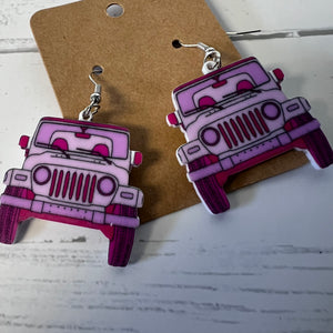Pink and purple jeep-shaped earrings on a brown card with a white background