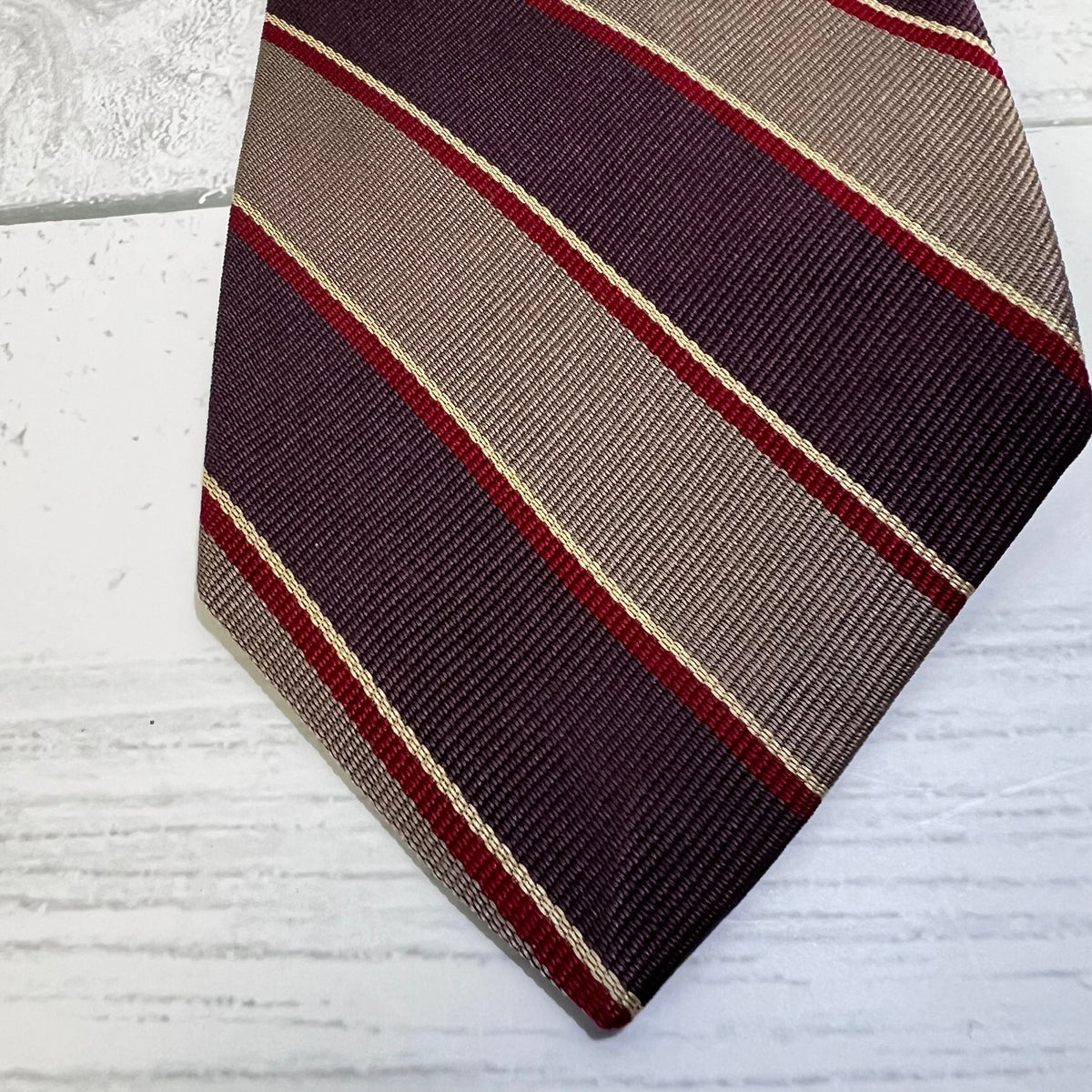 Striped tie with diagonal pattern on a light wooden surface