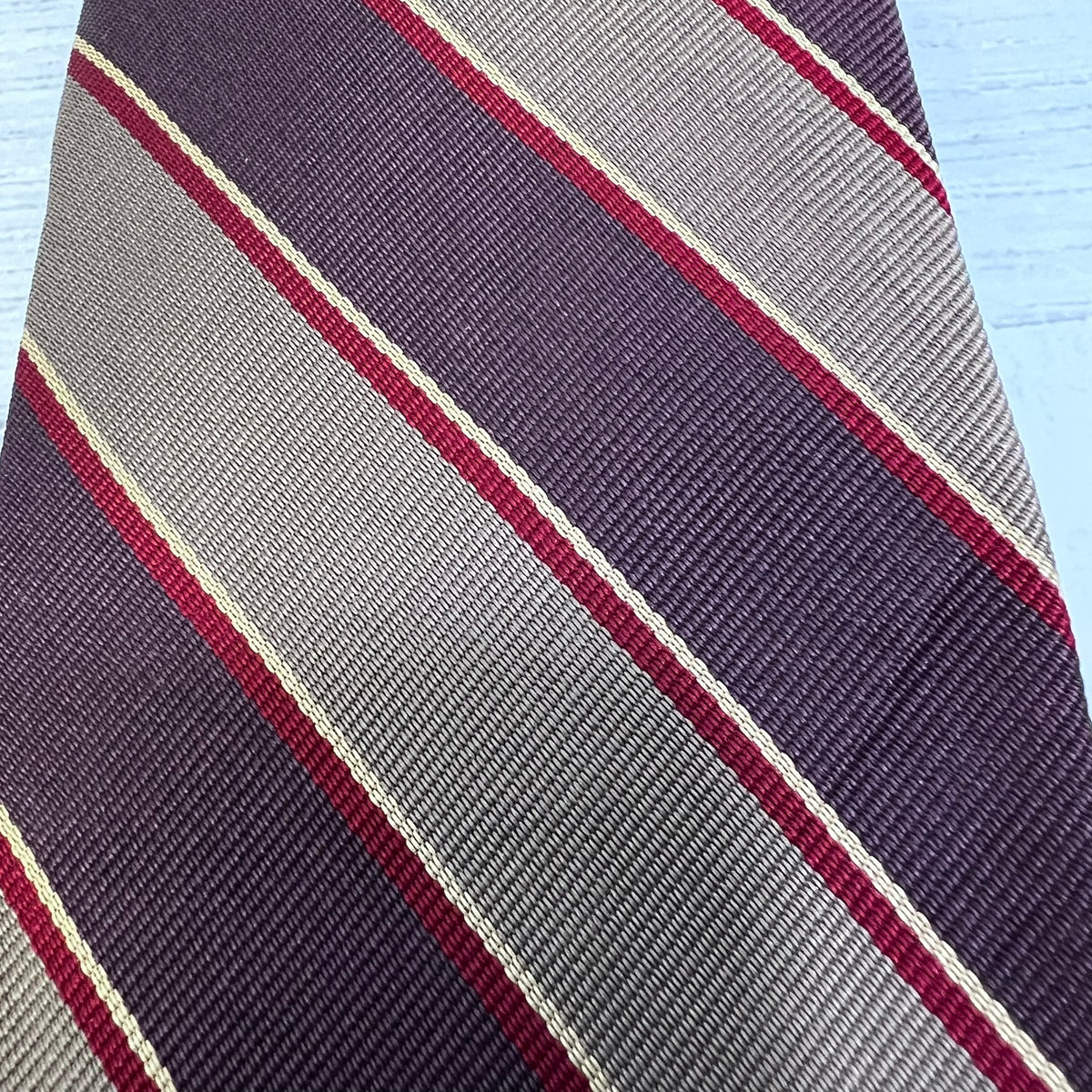 Striped tie with diagonal pattern on a light blue background