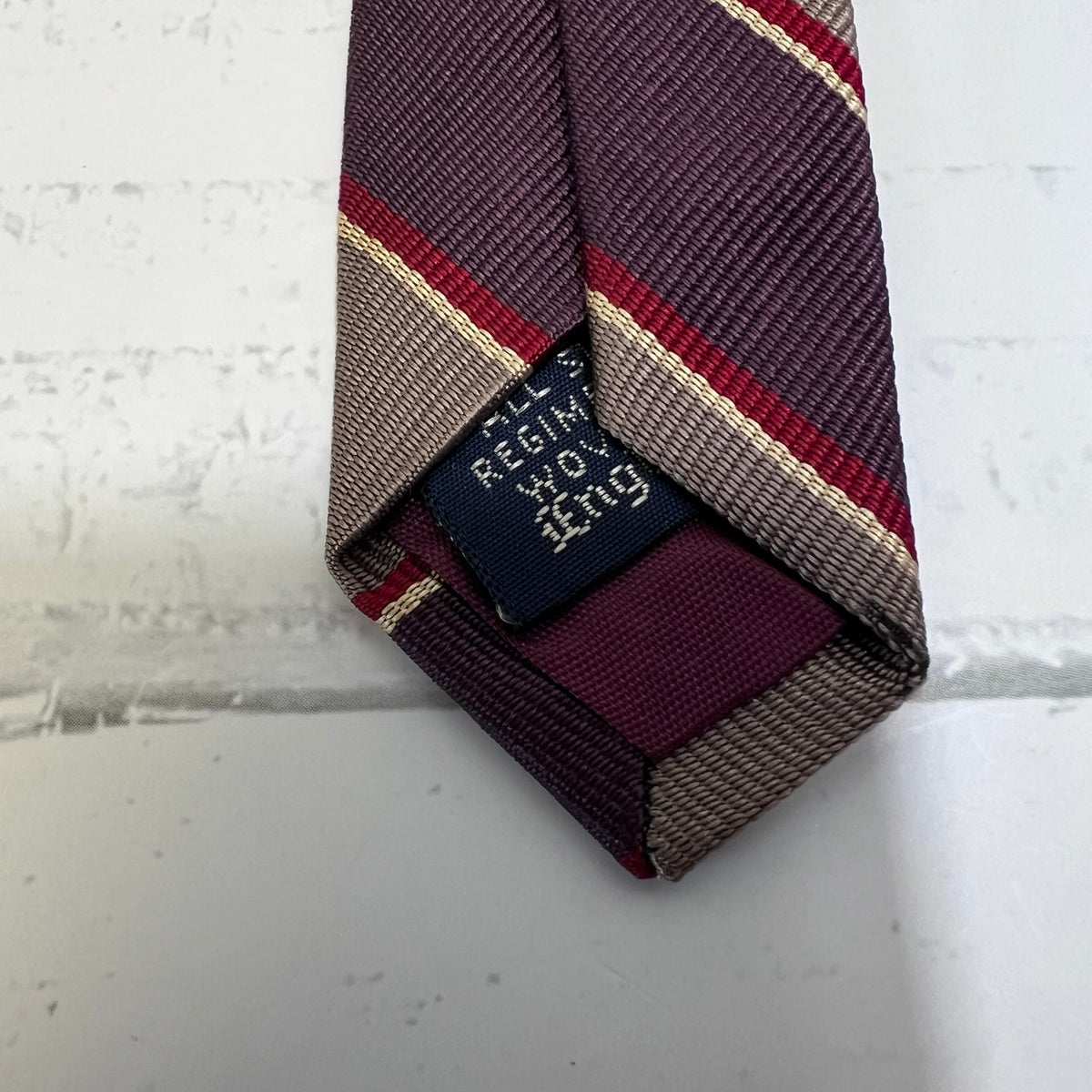 Patterned tie with a label on a light gray background