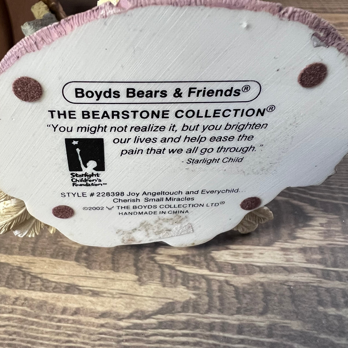 Label from Boyds Bears & Friends Bearstone Collection on a wooden surface
