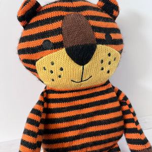 Knitted tiger toy with orange and black stripes on a white background