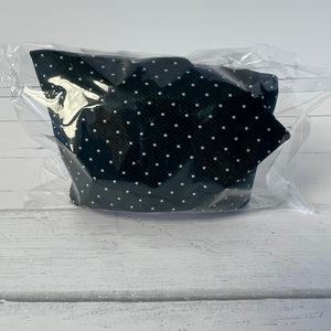 green polka dot tie with a silver logo in clear packaging on a light gray background