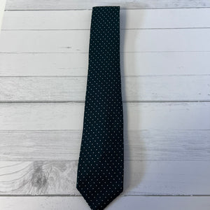 green tie with white polka dots on a light wooden surface