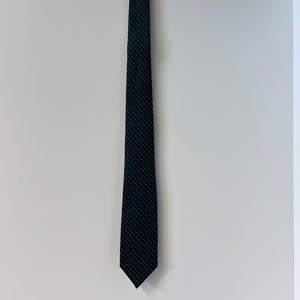 Black tie with white polka dots on a light gray background