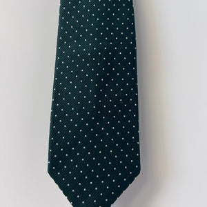 Dark green tie with white polka dots on a light gray background