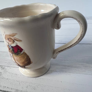 Ceramic mug with a rabbit illustration on a wooden surface