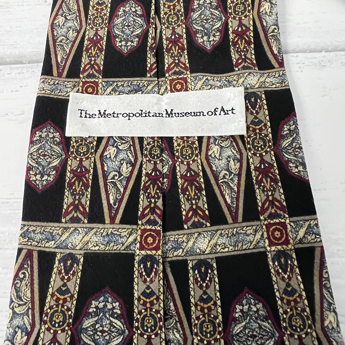 Decorative fabric with intricate patterns and a label from The Metropolitan Museum of Art.
