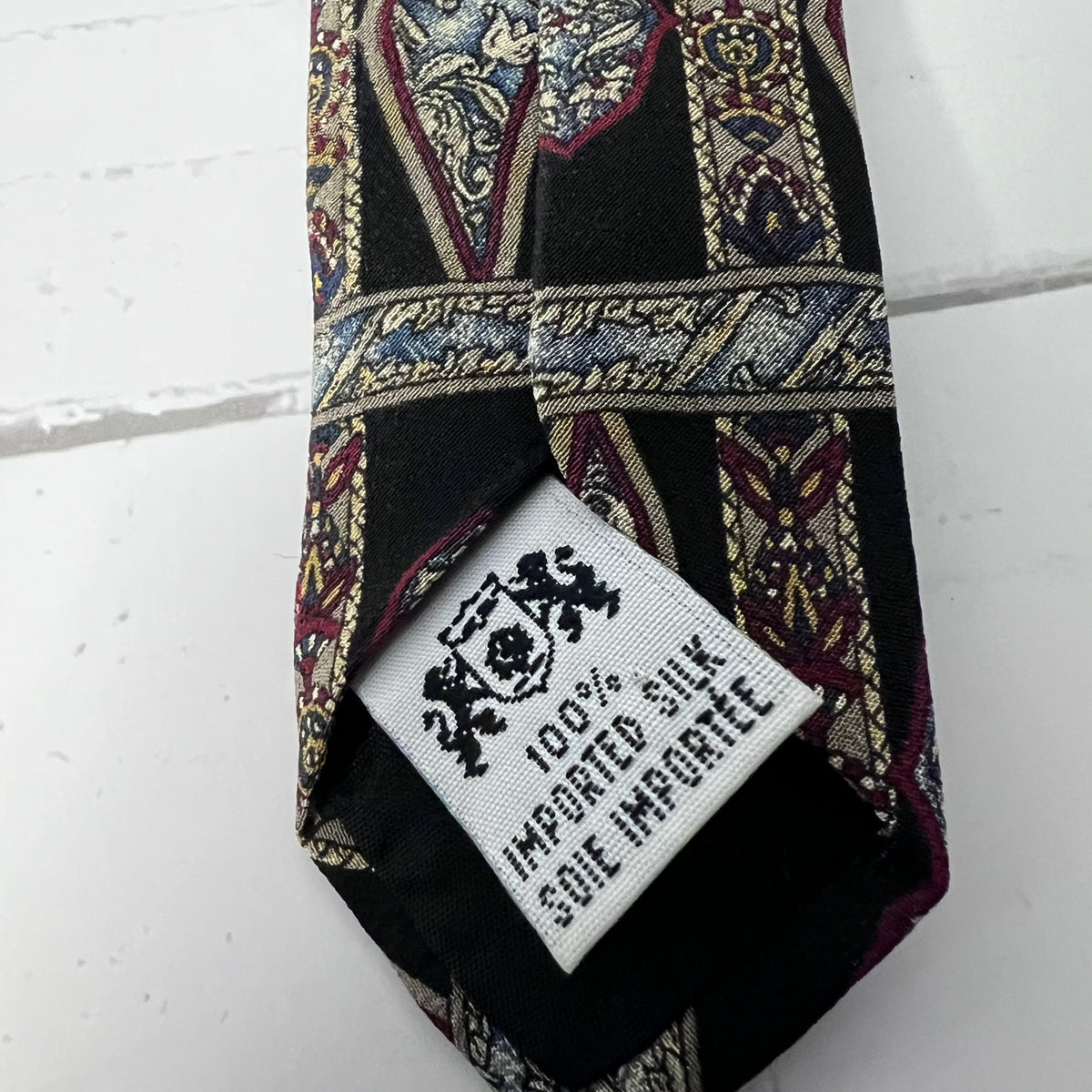 Patterned silk tie with a label on a white background