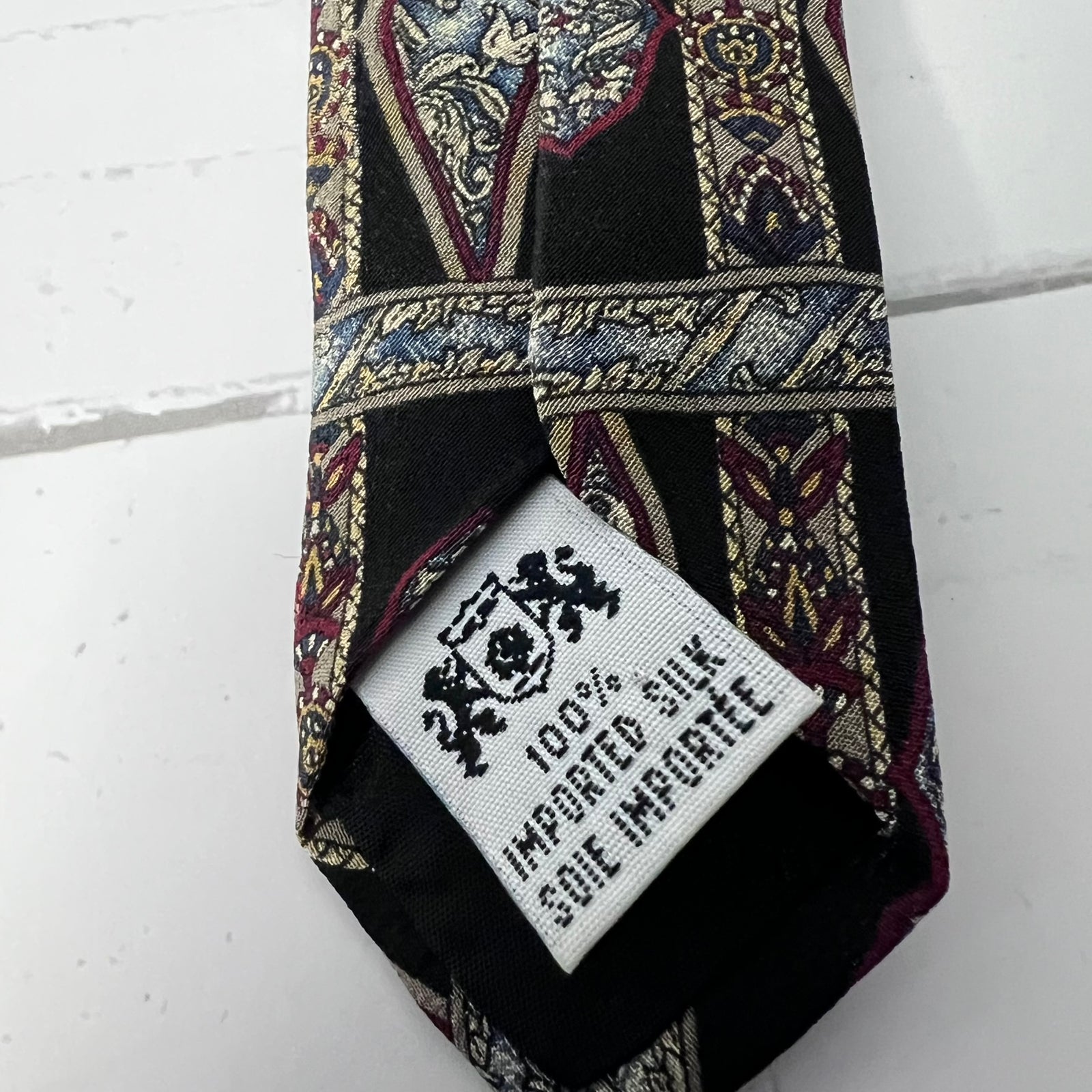 Patterned silk tie with a label on a white background