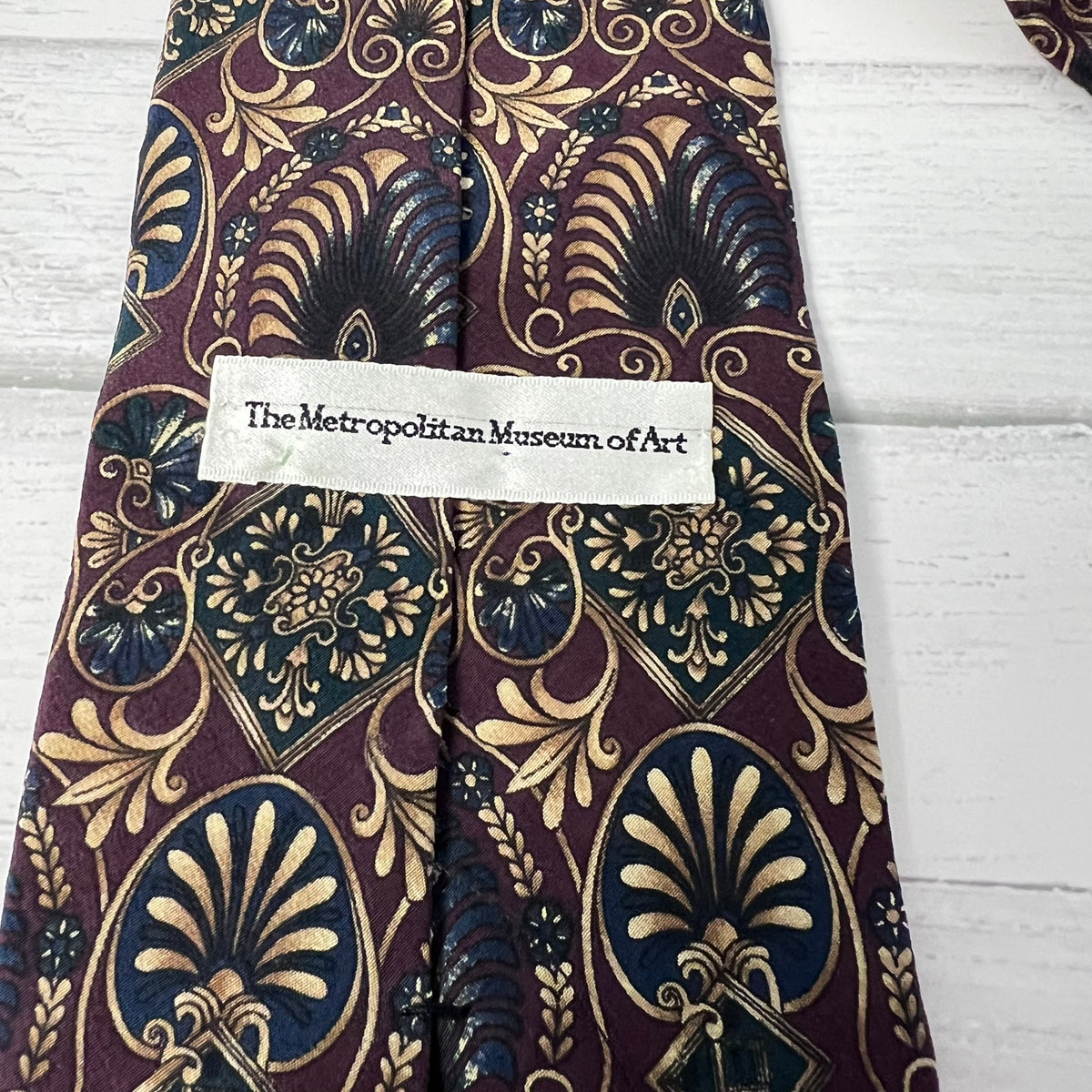 Patterned tie with a label on a wooden surface