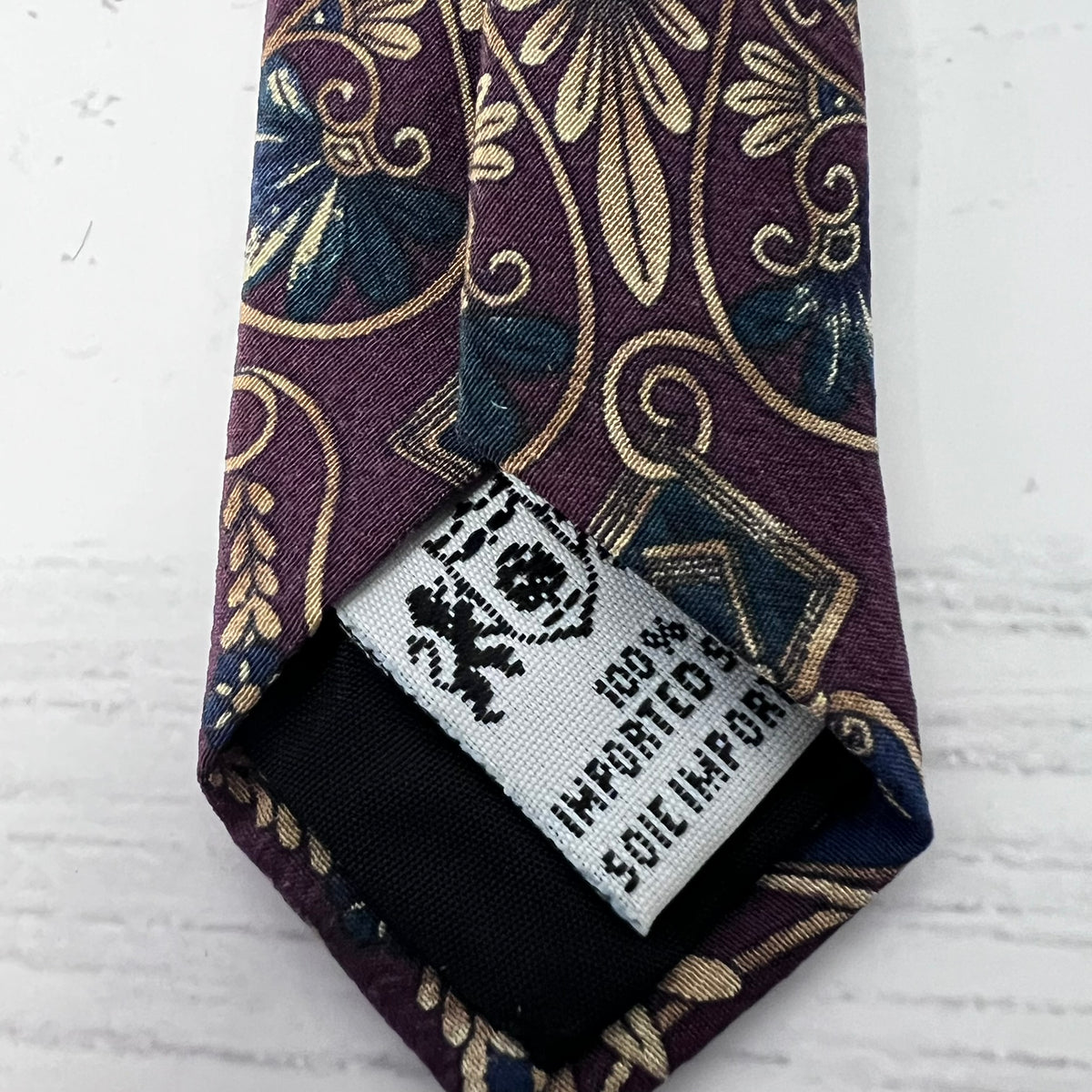 Patterned tie with a label on a textured white background