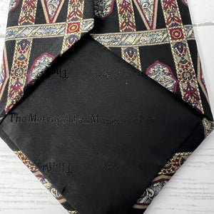Black pocket square with patterned tie on a white background