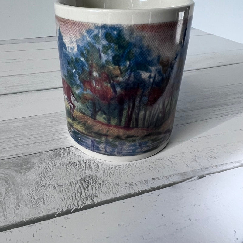 Mug with a scenic design on a wooden surface