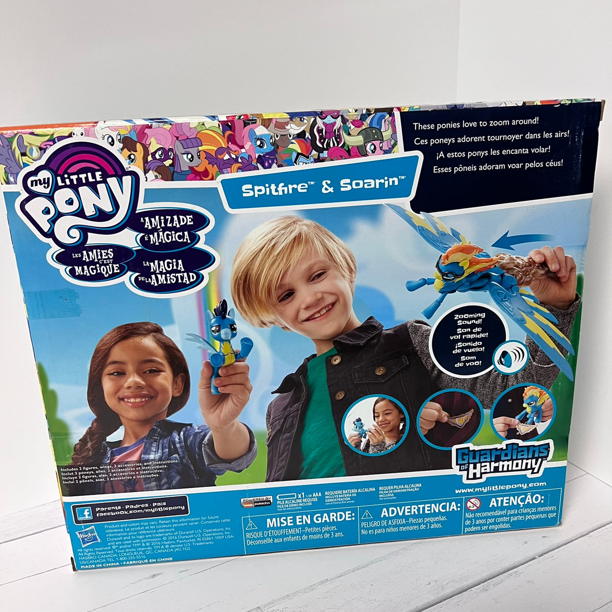 My Little Pony toy packaging with children holding ponies on a white background
