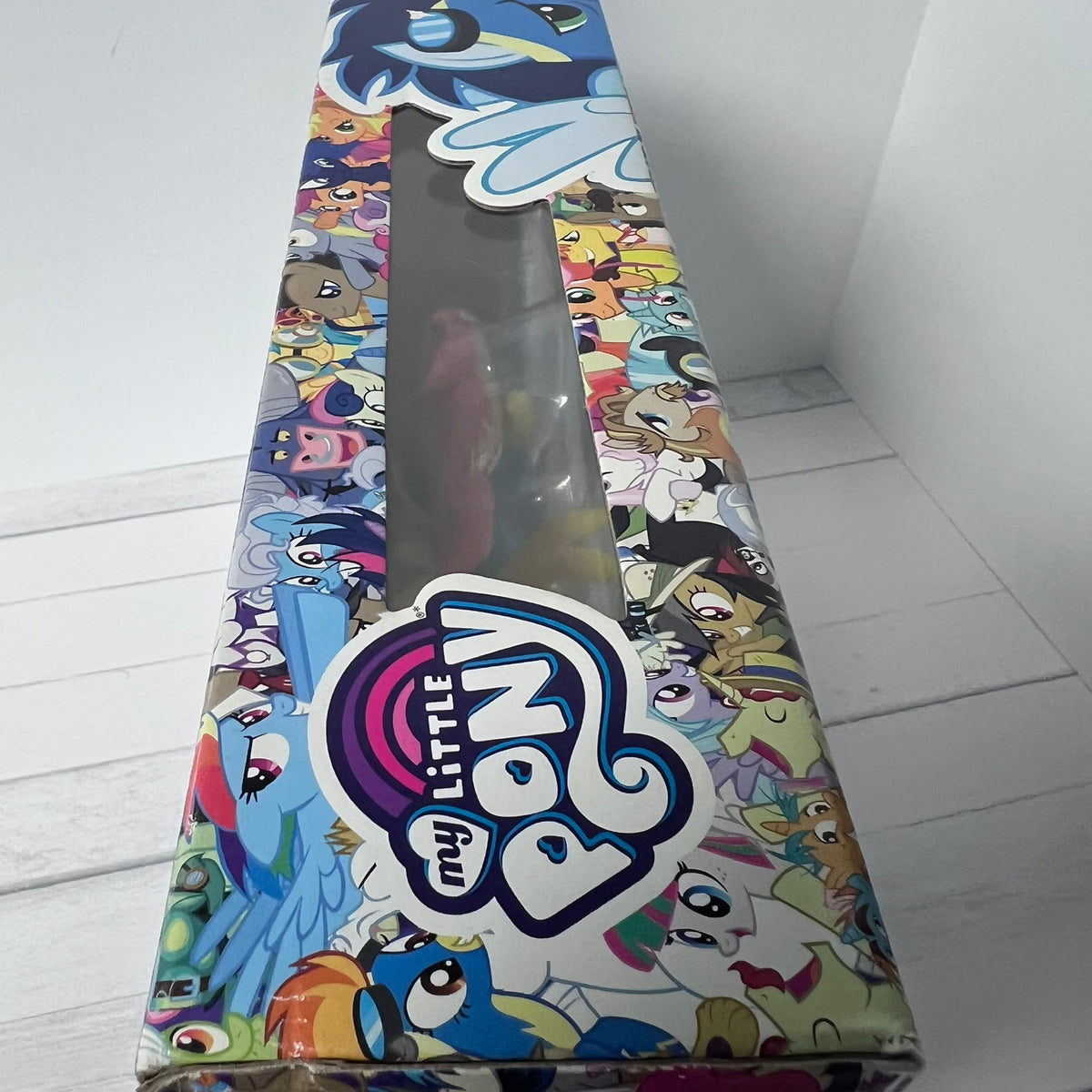 My Little Pony toy packaging with colorful characters on a white floor.