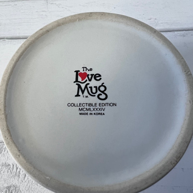 Back of a ceramic mug with 'The Love Mug' branding and details.