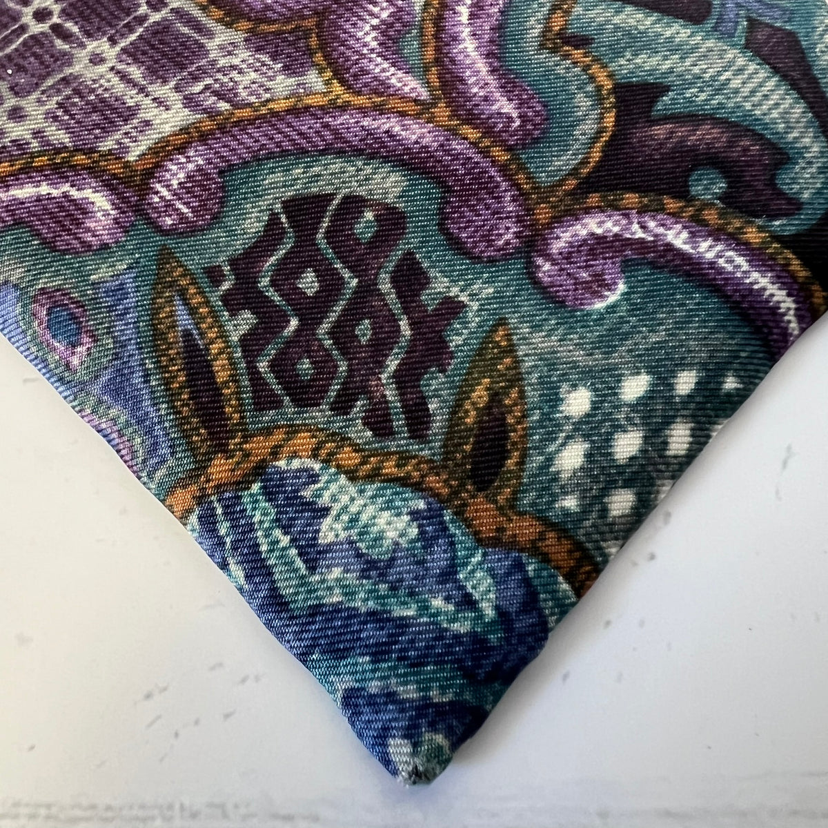 Close-up of a patterned fabric with intricate designs on a white background