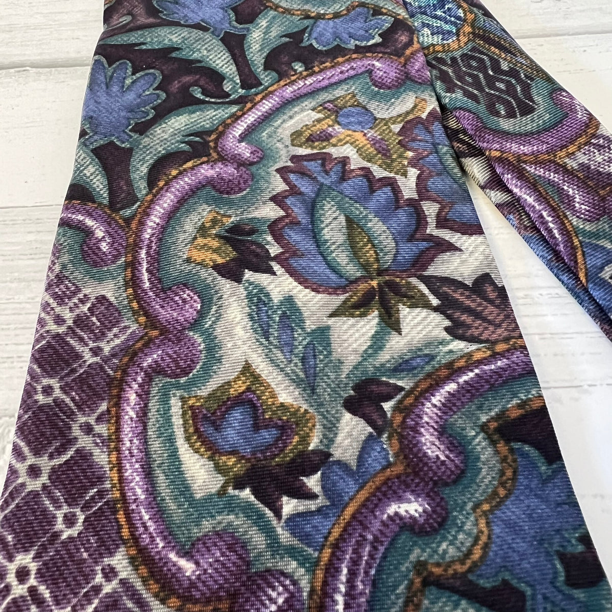 Close-up of a patterned fabric with intricate designs on a wooden surface