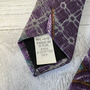 Close-up of a patterned tie with a label on a textured surface