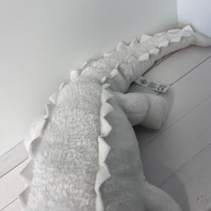 Plush dinosaur toy on a light wooden floor