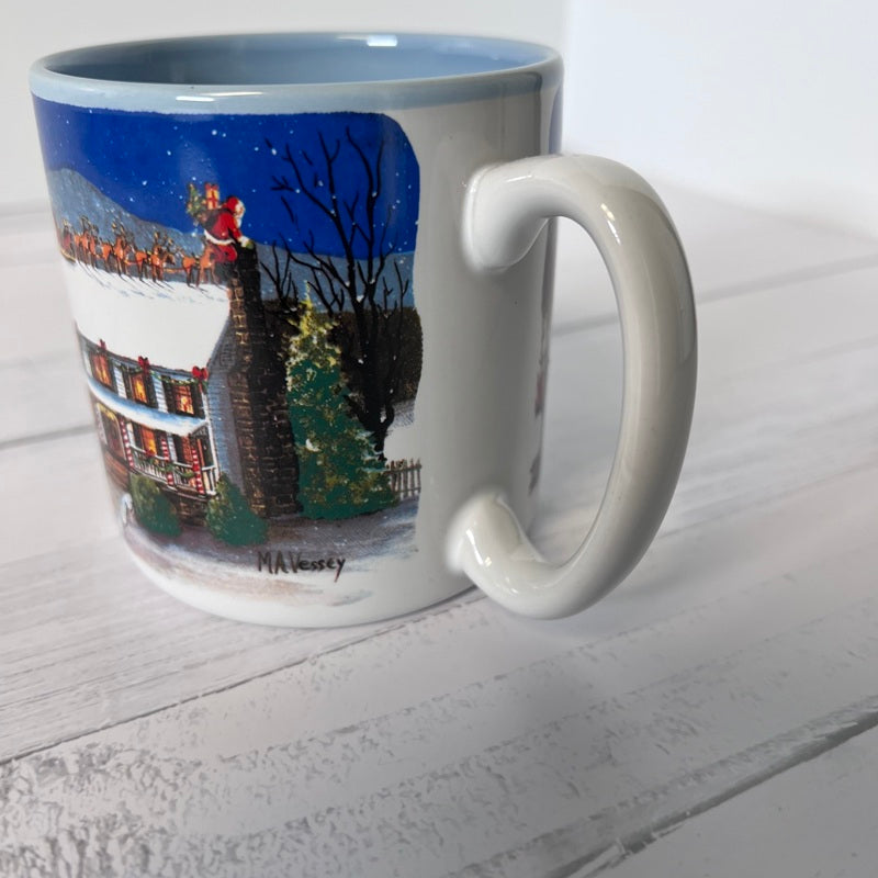 Mug with a winter scene of a house and tree on a white surface