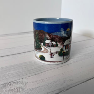 Mug with a winter scene design on a white wooden surface