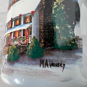 Mug with a winter scene of a house and trees, signed 'MA Vessey'.