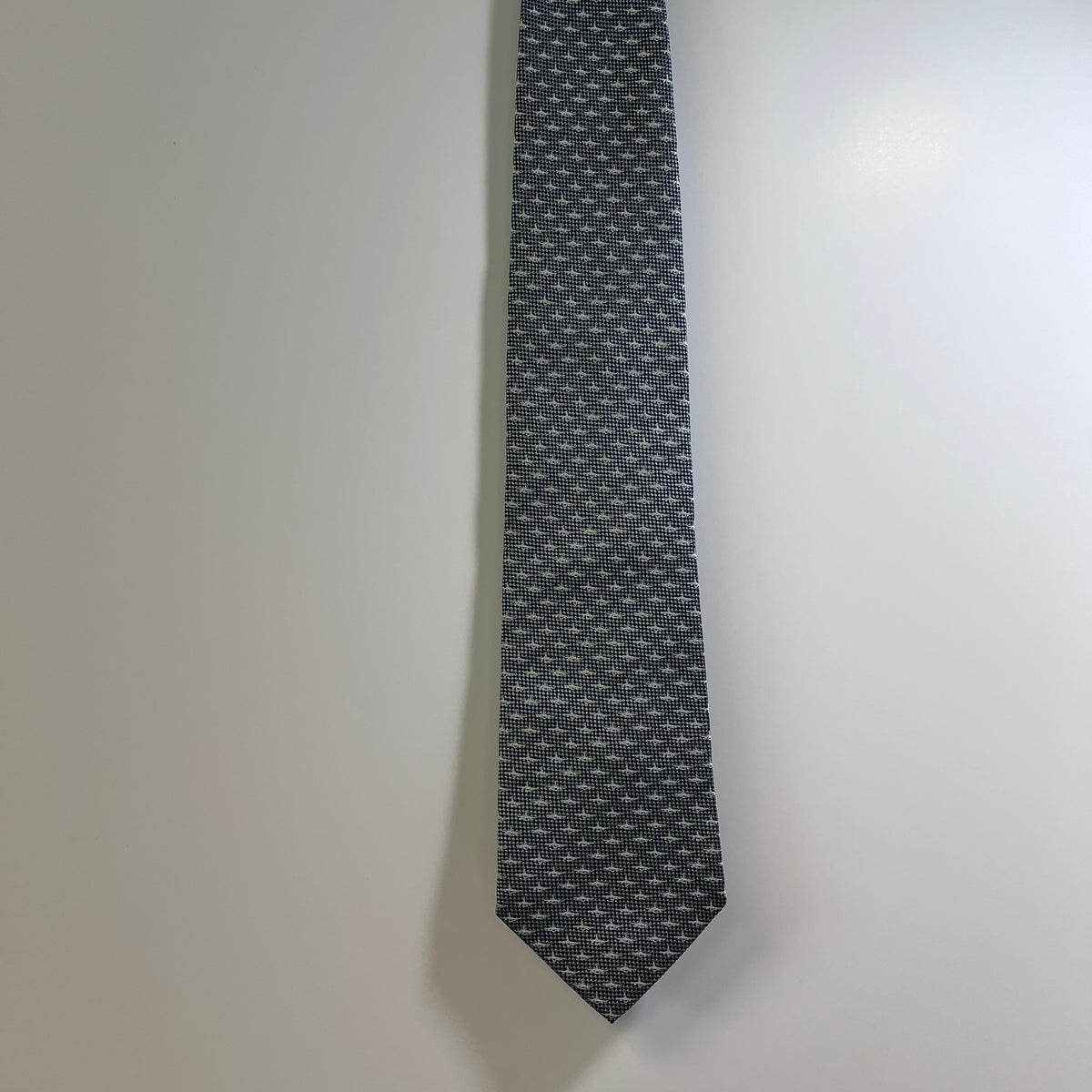 Black patterned tie on a light gray background