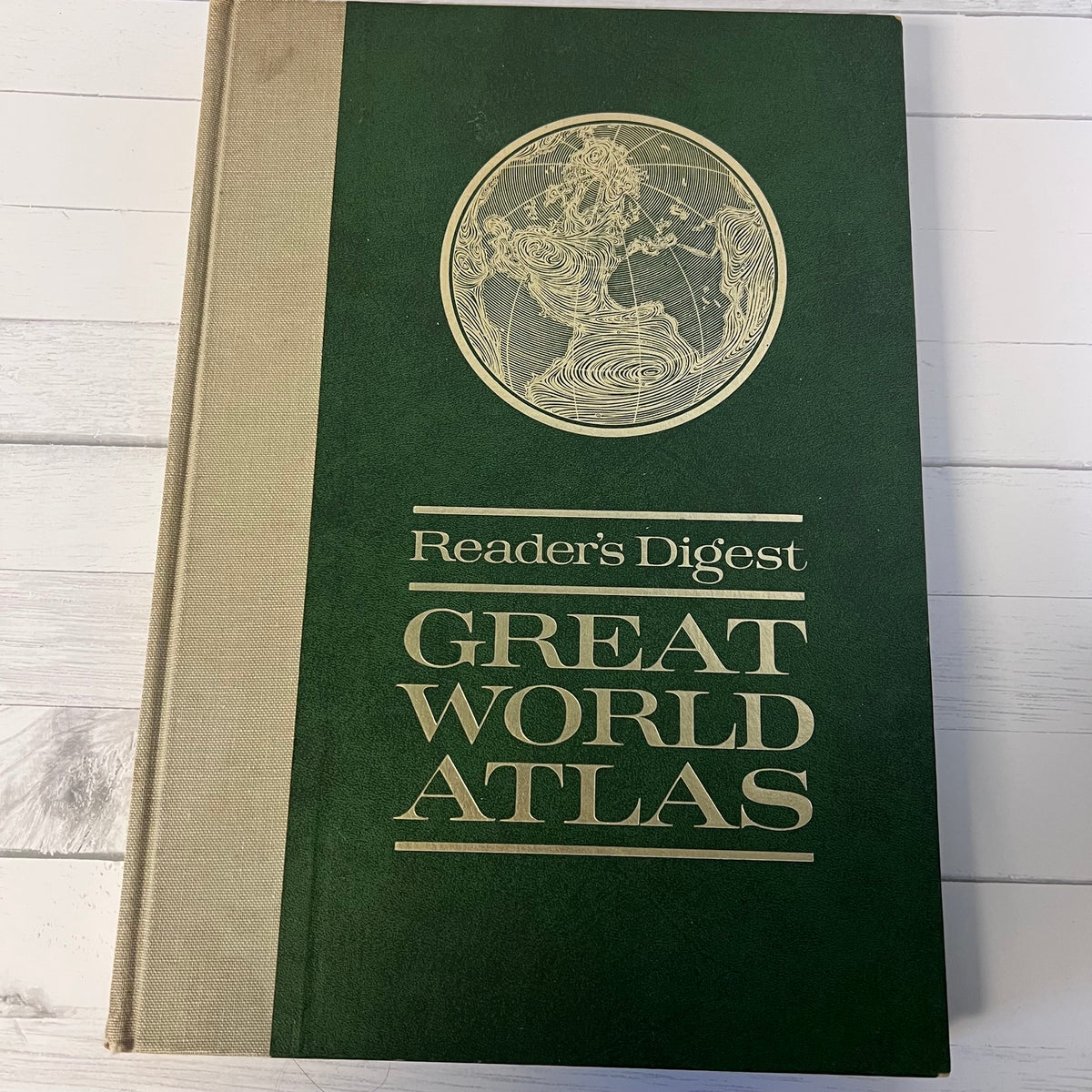 Reader's Digest Great World Atlas on a wooden surface