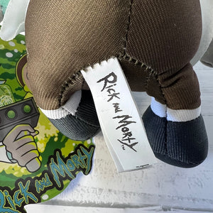 Plush toy with a tag featuring 'Rick and Morty' branding, placed on a surface with a colorful background.