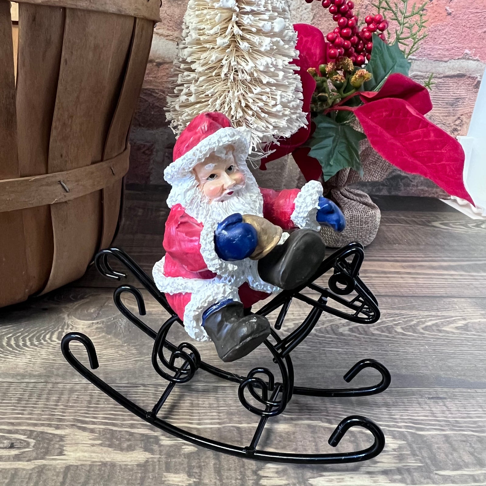 Decorative figure of Santa Claus on a sleigh with Christmas decorations in the background.