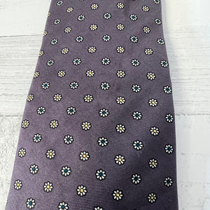 purple tie with small white floral pattern on a light wooden surface