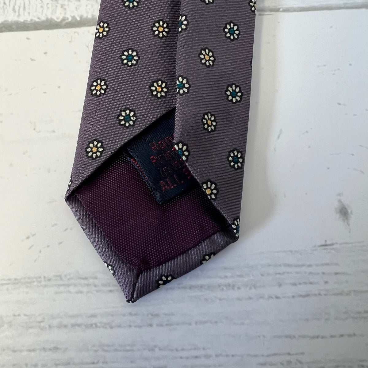 Folded patterned tie on a textured surface
