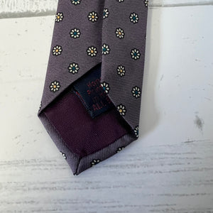 Folded patterned tie on a textured surface