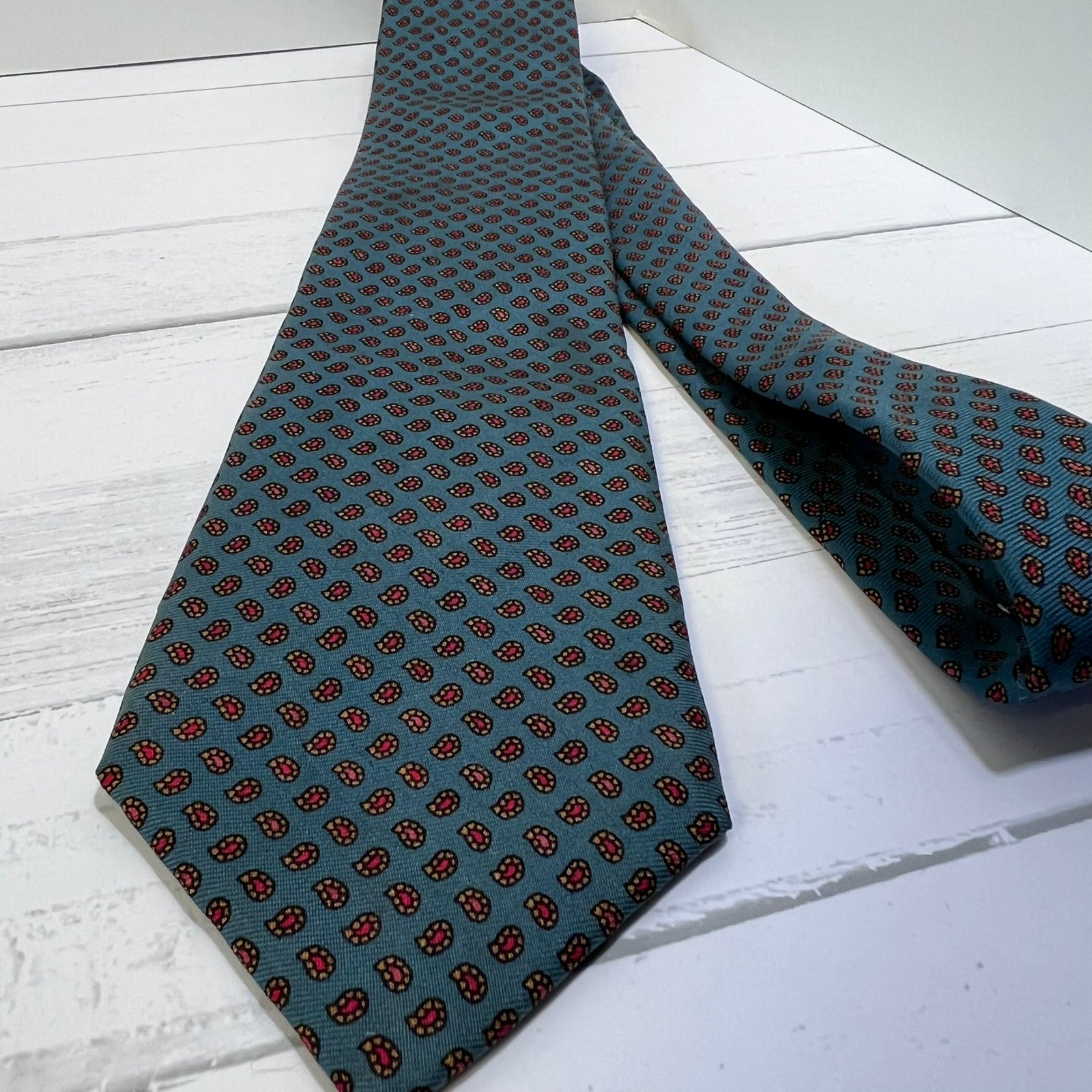 Green patterned tie on a white wooden surface