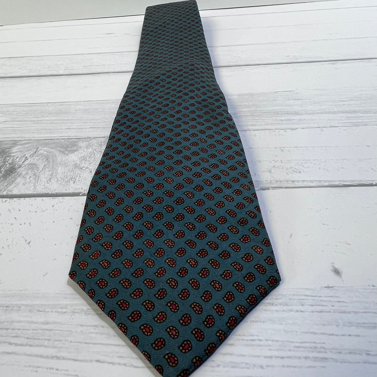 Black patterned tie on a light wooden surface