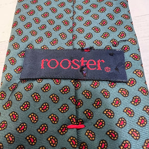 Patterned tie with 'rooster' brand label on a light blue background