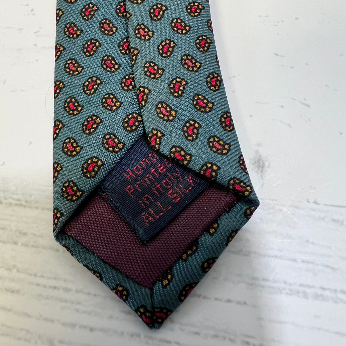 Patterned tie with a pocket square on a textured white surface