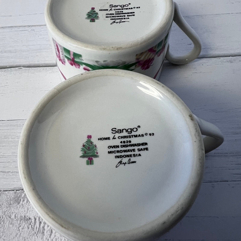 Two ceramic mugs with 'Sango' branding on a wooden surface