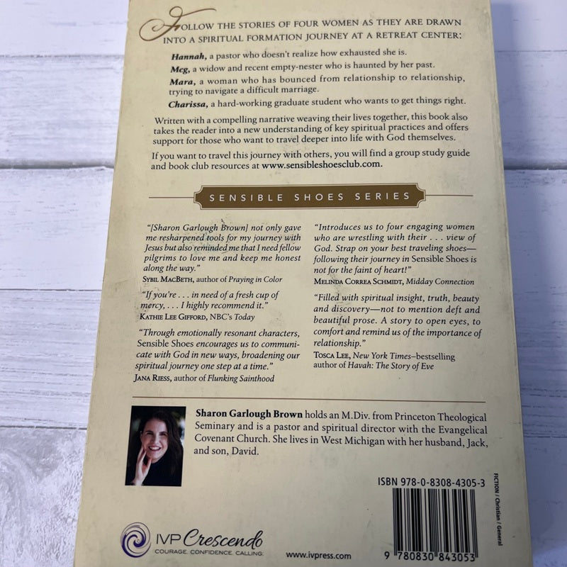 Back cover of a book with text and a photo of a woman on a wooden surface