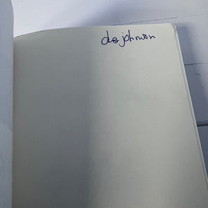 Notebook with 'de johnson' written on the cover against a white background