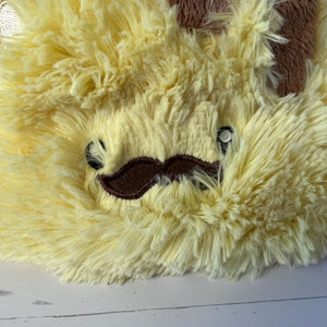 Close-up of a plush toy with a yellow fur texture and a mustache on a white background