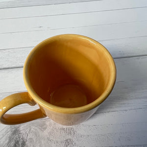 Yellow mug on a light wooden surface