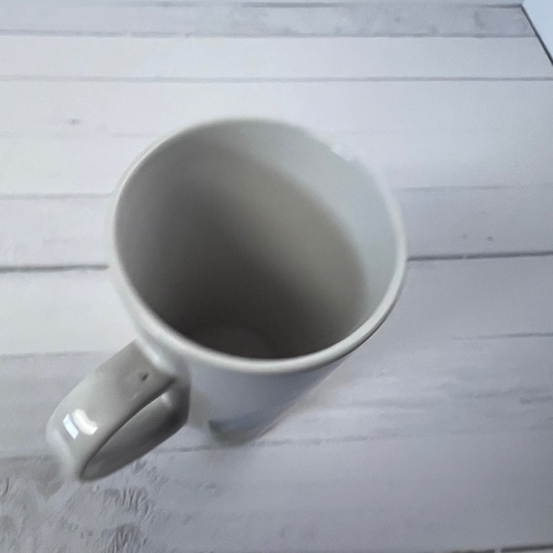 White ceramic mug on a light wooden surface