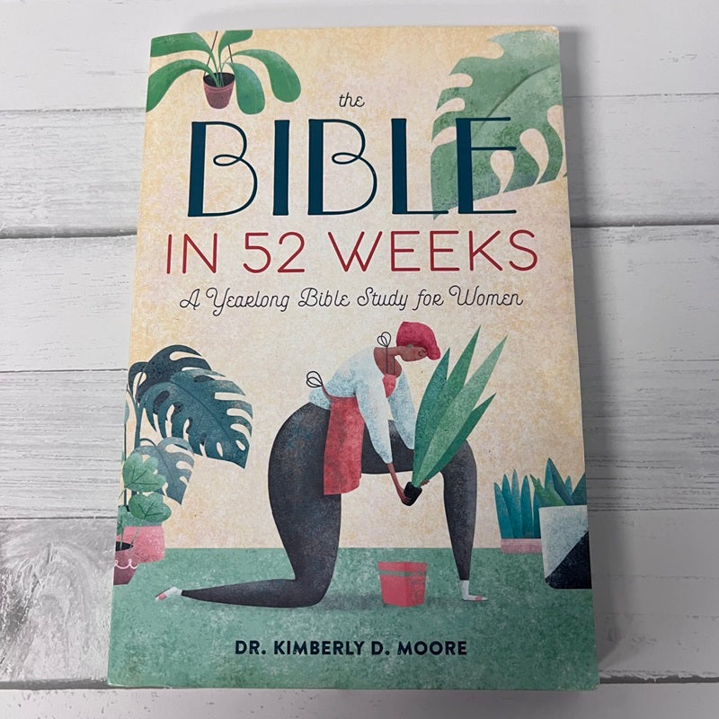 Book titled 'The Bible in 52 Weeks' on a wooden surface