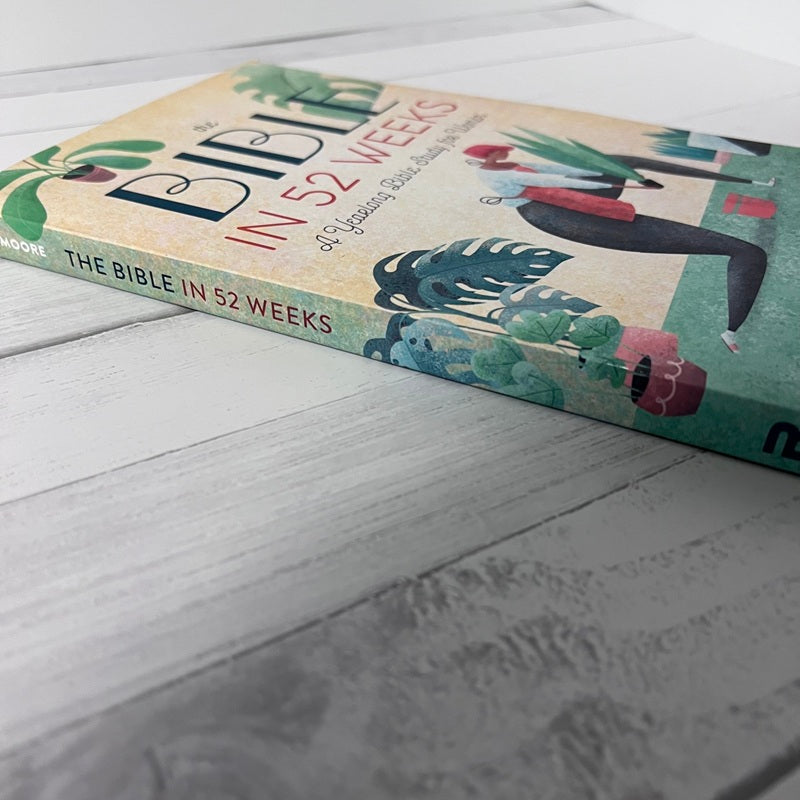 Book titled 'The Bible in 52 Weeks' on a wooden surface