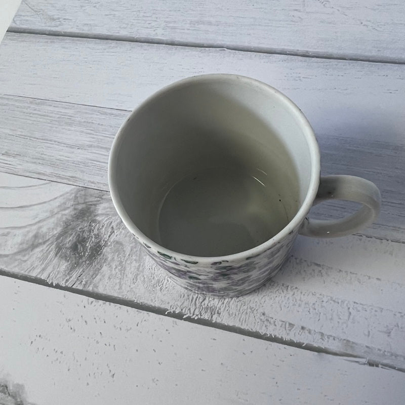 Empty ceramic mug on a textured wooden surface