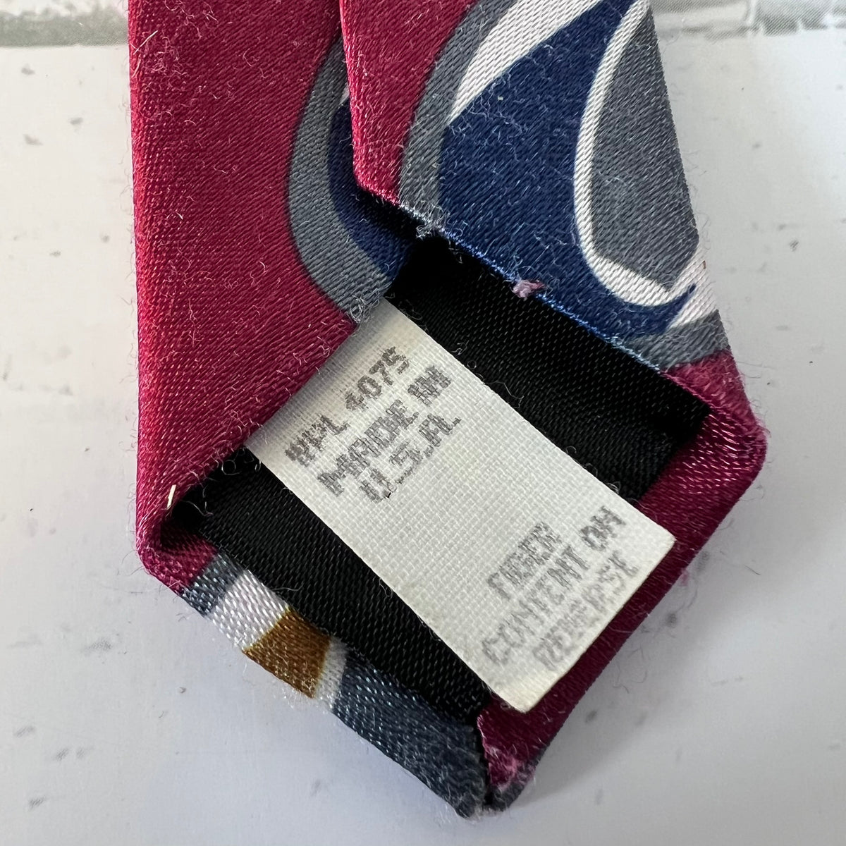 Colorful tie with a label on a light gray background